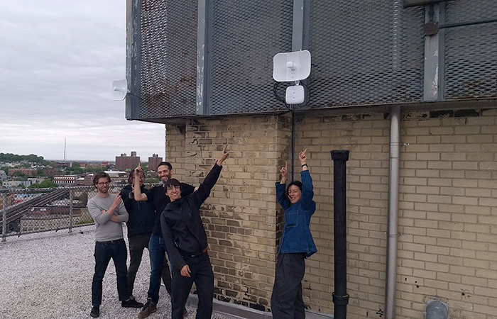 Volunteers pointing to antenna installation at Saratoga Village